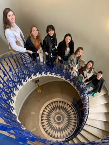 A group of students poses on a spiral staircase.