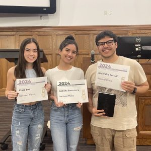 Three college students smile, holding up certificates