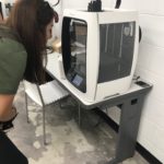 Student watches her design come to life on the 3D printer.